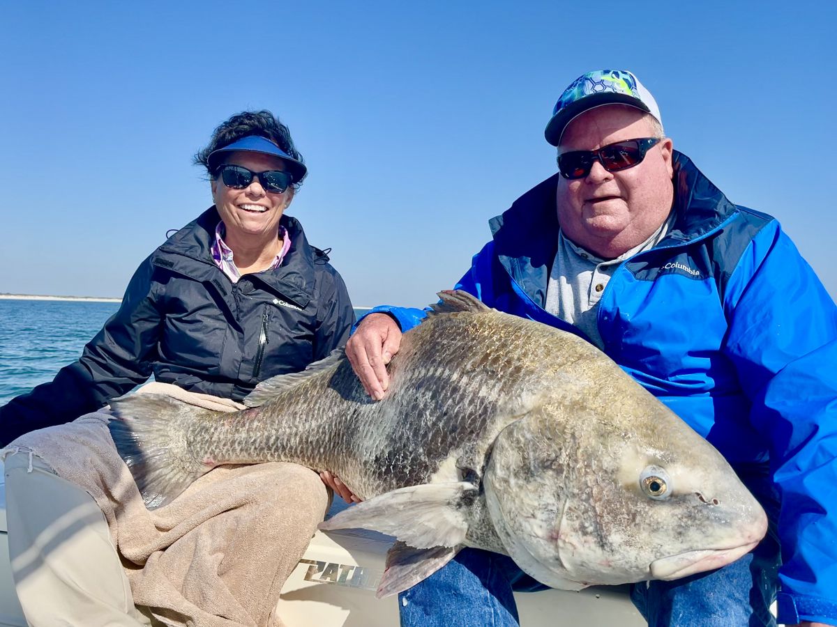 Man and Woman Holding A Black Drum